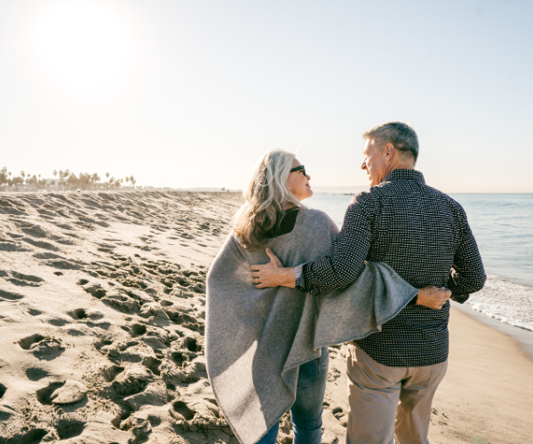 older couple walking on beach