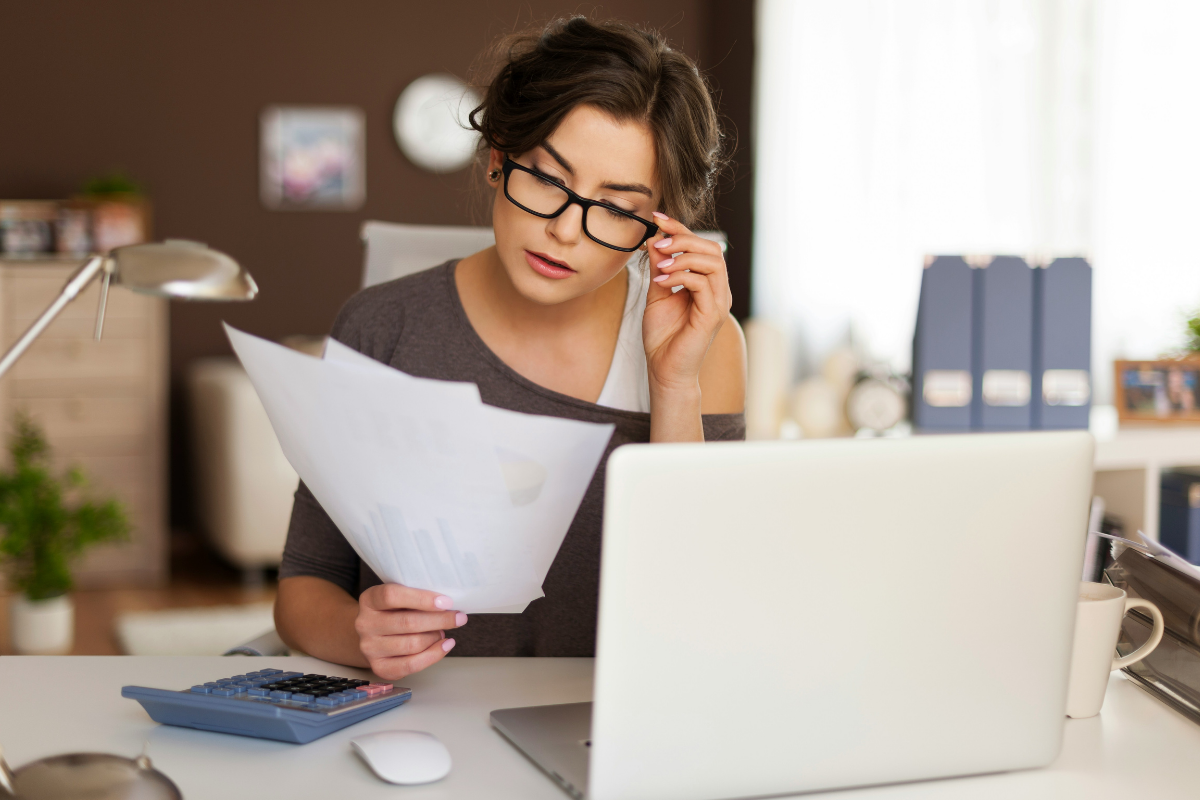 Individual reviewing financial documents on a laptop at home, symbolizing secure online access to IRS tax records and digital financial management.